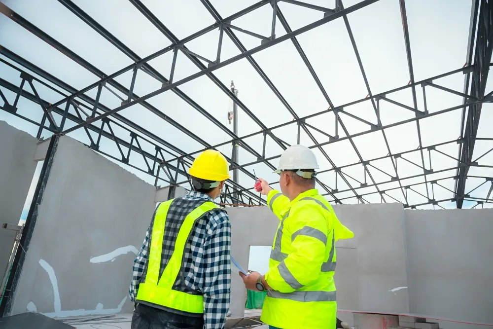Two professional building inspector discussing while pointing up