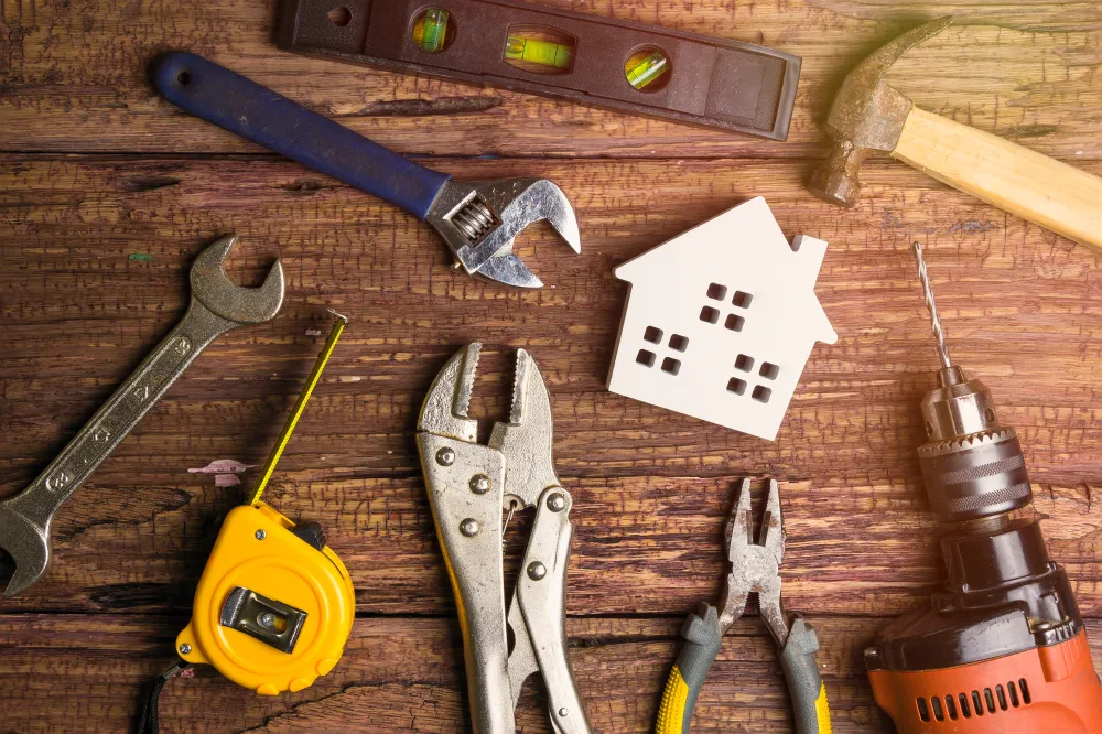 Assorted home repair tools on wooden workbench