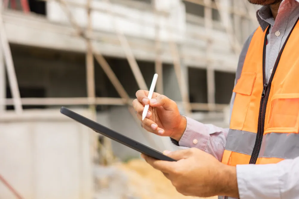 Construction worker using tablet on building site