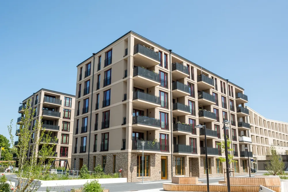 Modern multi-storey apartment building with balconies and courtyard