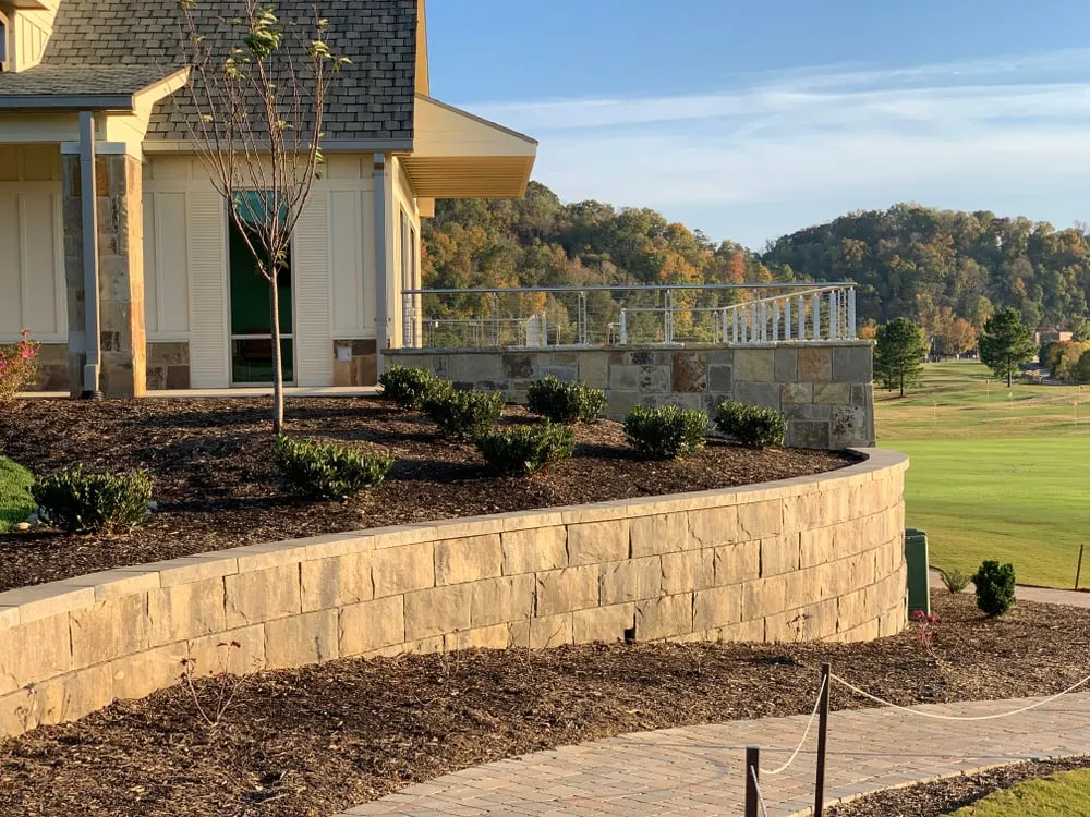 Modern house with stone retaining wall overlooking golf course