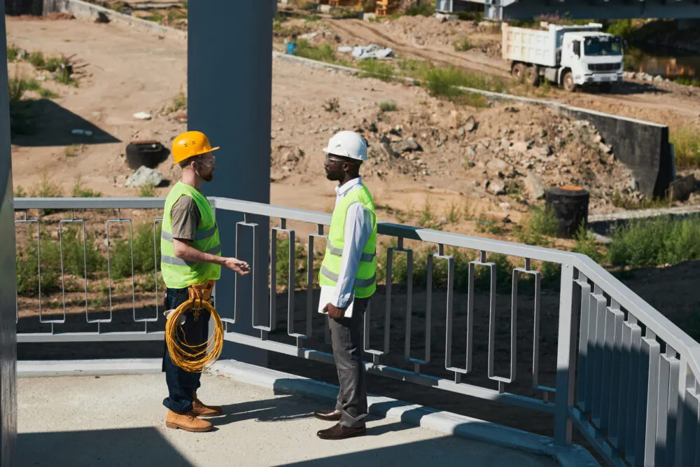 Construction workers discussing project on bridge site