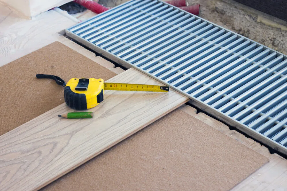 Measuring timber flooring near floor vent installation