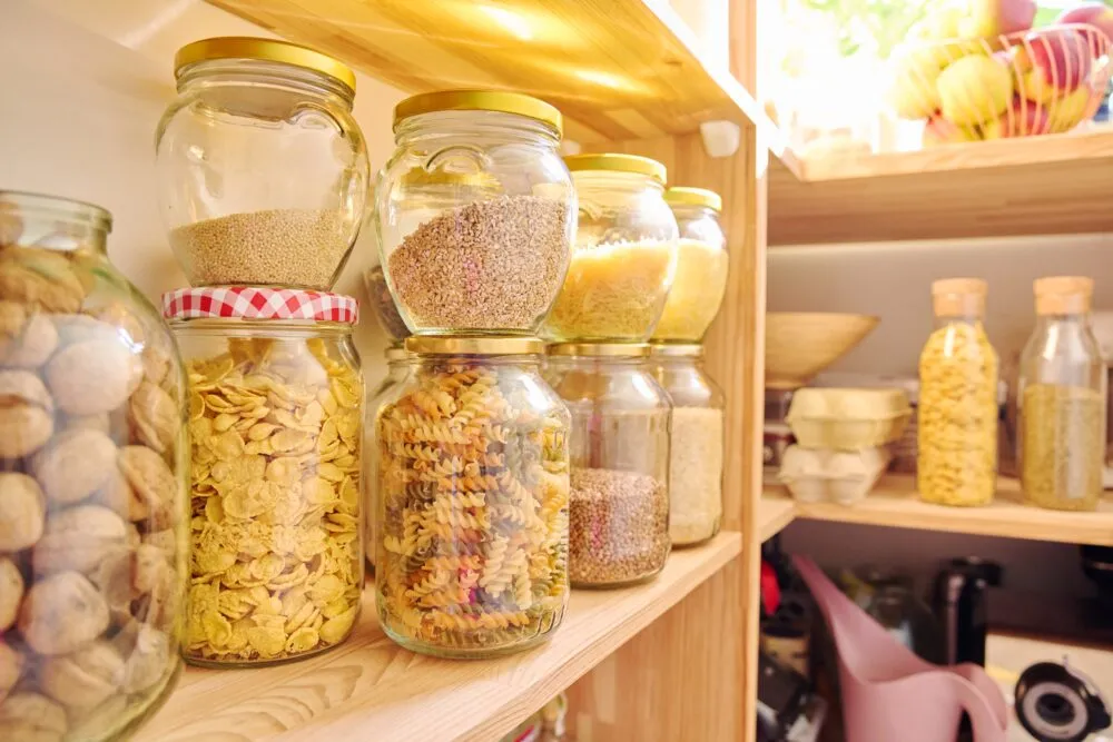 Glass jars of grains and pasta on pantry shelves