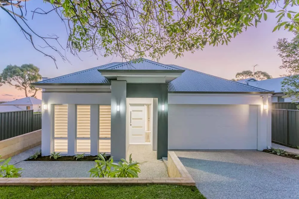 Modern single-storey home with double garage at dusk