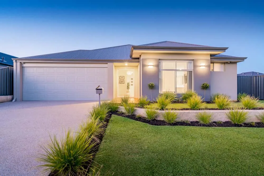 Modern single-storey home with double garage at dusk